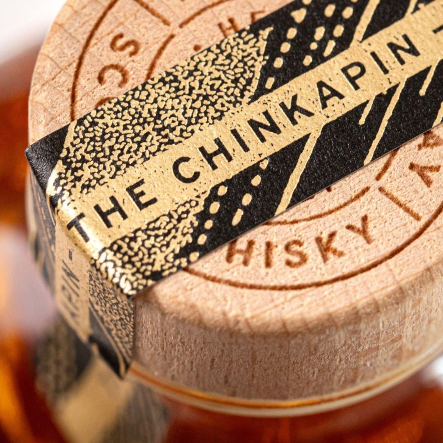 Close-up of the wooden cork and decorative label on a Schwarzbach Spirits Isle of Raasay Chinkapin Oak whisky bottle.
