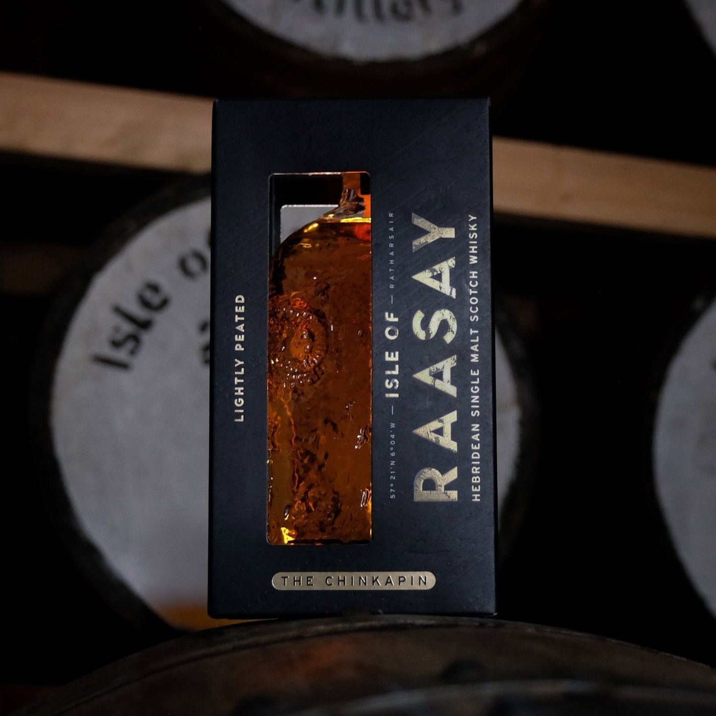 Schwarzbach Spirits Isle of Raasay The Chinkapin single malt whisky bottle in a black box against a barrel background