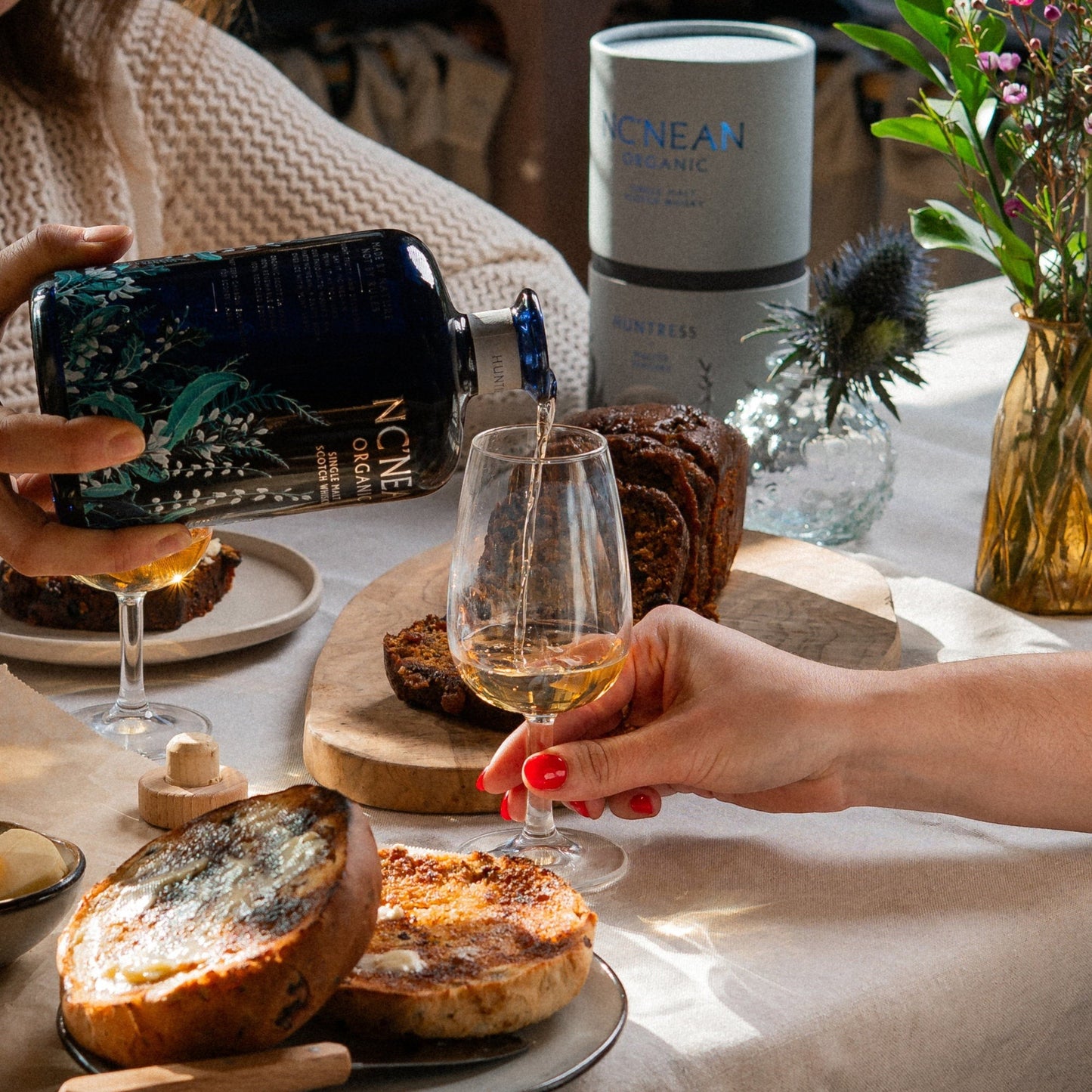 Schwarzbach Spirits: Nc'nean Huntress Malted Teacake Single Malt Whisky wird eingeschenkt, serviert mit Kuchen und Toast.