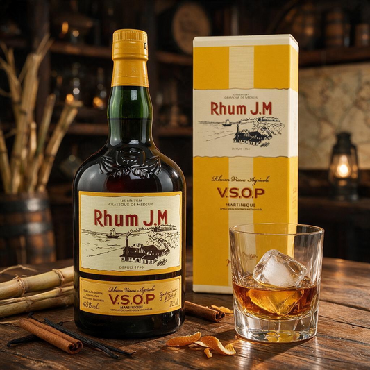 Schwarzbach Spirits Rhum J.M VSOP Agricole in Geschenkverpackung mit Glas, Eiswürfeln und Zuckerrohr auf Holztisch