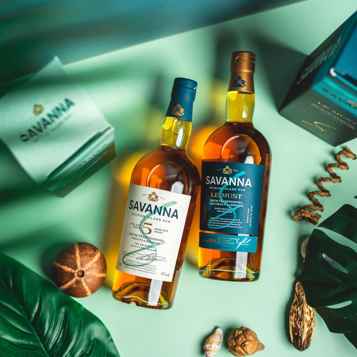Schwarzbach Spirits Savanna 5 Jahre Traditionnel Rhum und Le Must Flaschen auf grünem Hintergrund mit Dekoration