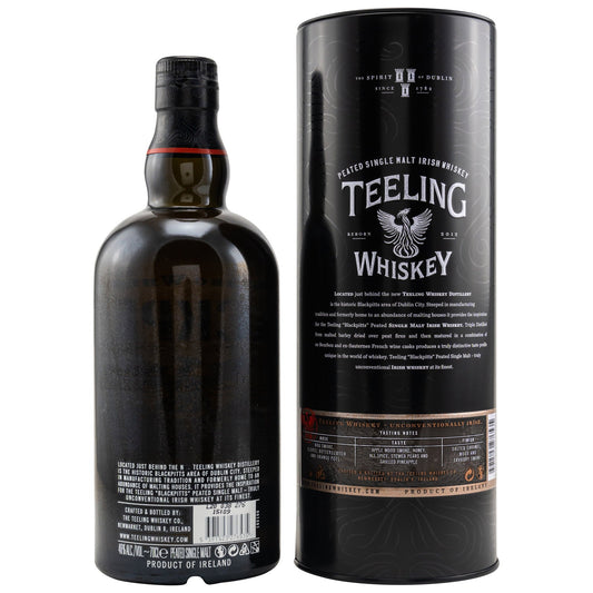 Schwarzbach Spirits Teeling Blackpitts Peated Irish Whiskey bottle and black cylindrical gift tube on white background.